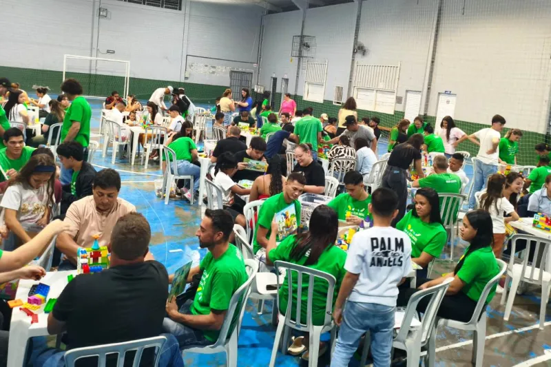 Em ginásio esportivo, familiares se reúnem para atividades integradas