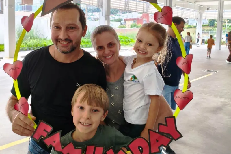 Família posa para foto "dentro" do quadro decorativo do dia da família